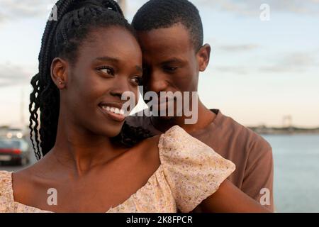 Smiling young woman standing in front of boyfriend Stock Photo