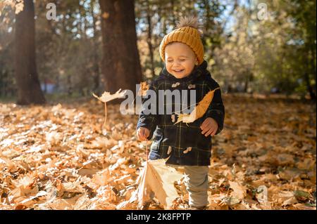 Smiling boy wearing knit hat playing in park in autumn Stock Photo