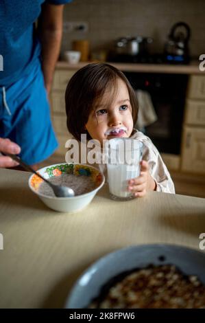 Son having breakfast by father on table at home Stock Photo