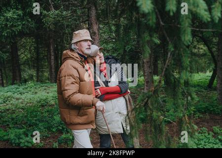 Thoughtful couple standing in forest Stock Photo