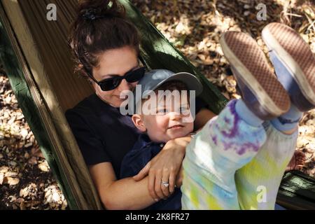 Smiling mother with son lying in hammock Stock Photo