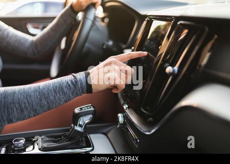 Woman's hand checking navigator sitting in car Stock Photo