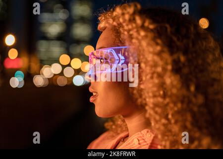 Young woman with curly hair wearing futuristic glasses Stock Photo