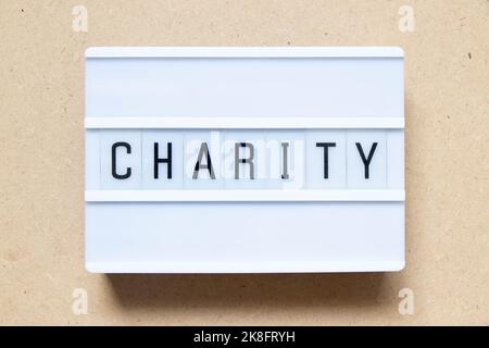 Lightbox with word charity on wood background Stock Photo