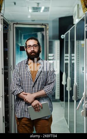 Computer programmer with beard holding tablet PC in server room Stock Photo