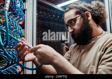 Concentrated IT expert connecting cables in data center Stock Photo