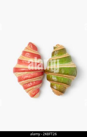 Pink and green striped croissants on white background Stock Photo