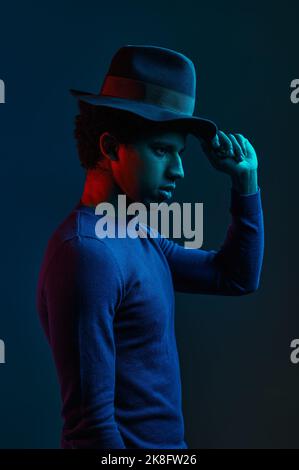 Stylish outlook man in hat on dark background Stock Photo