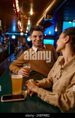Man and woman talking while enjoying drinks together Stock Photo