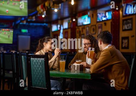 Friends having fun sitting at the table in the pub Stock Photo