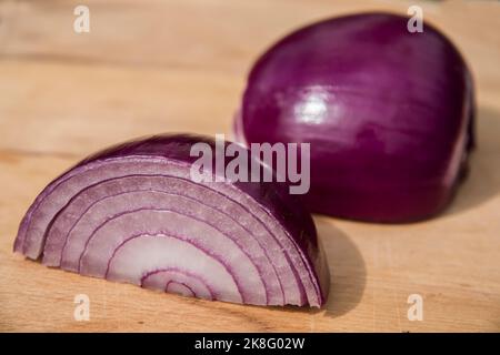 Fresh red onion and cut in half sliced on wooden board background Stock Photo