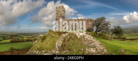 On a day of sunshine and showers on the edge of Dartmoor National Park, the sun lights up the iconic Devon landmark church of St Michael de Rupe perch Stock Photo