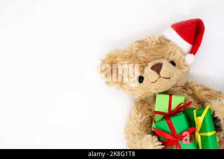 Teddy bear in Santa Claus hat holds gift boxes. Copy space. Stock Photo