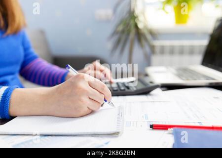 Woman using using calculator for calculate home finances or car taxes Stock Photo