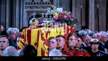 FUNERAL Queen Elizabeth II Funeral bearer party carry her Majesty’s coffin into the interior centre of Saint George’s Chapel with the Sovereign’s standard flag draped, the Crown Orb & Sceptre placed on top. Princess Anne follows her mother’s coffin along with close members of The Royal Family. UHD Broadcast still.19th September 2022 Windsor Castle Berkshire UK Stock Photo