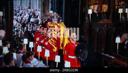 FUNERAL Queen Elizabeth II Funeral bearer party carry her Majesty’s coffin into the interior centre of St. George’s Chapel with the Sovereign’s standard flag draped, the Imperial State Crown, Orb & Sceptre placed on top. The (then) British Prime Minister Liz Truss can be seen top right in a private stall. UHD Broadcast still.19th September 2022 Windsor Castle 9 Sept 2022 — The State Funeral Her Majesty Queen Elizabeth II