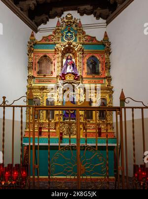 Altarpiece in the La Conquistadora Chapel is in the north transept of the Cathedral Basilica of Saint Francis of Assisi in Santa Fe, New Mexico.  The Stock Photo