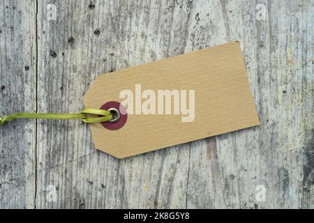 Blank card with a green ribbon lies on a weathered wooden background Stock Photo