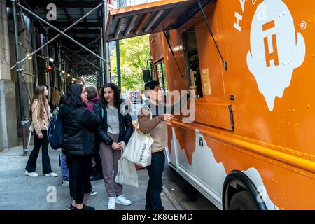 Ice cream lovers line up at the Halo Top “Pumpkin Responsibly” truck for samples of the brand’s Pumpkin Pie flavor ice cream and pumpkin pie flavored lattes (made with Halo Top) in the NoMad neighborhood of New York on Wednesday, October 19, 2022. Halo Top is owned by Wells Enterprises, also the maker of Blue Bunny ice cream. (© Richard B. Levine) Stock Photo