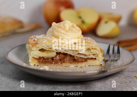 piece of an apple strudel roll with cinnamon and ice cream on top Stock Photo
