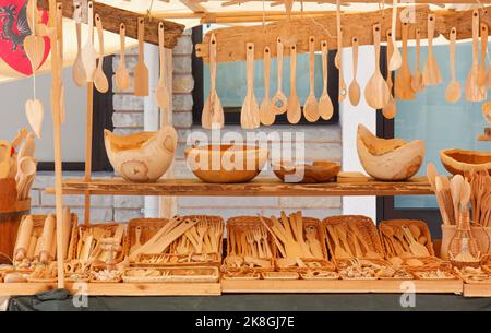 Stand at a street market selling wooden kitchen utensils as bowls, ladles and cutlery Stock Photo