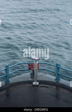 From above binoculars installed on wet viewpoint near waving sea on stormy day on embankment in city in Turkey