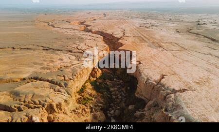 Breathtaking drone view of rough crack in dry soil of desert on sunny day in Iran Stock Photo