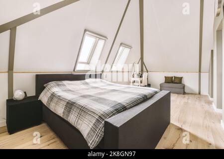 Interior of spacious bedroom located in attic of house in daytime Stock Photo