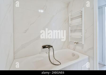 White hydromassage bathtub and towel warmer in modern luxurious bathroom at home Stock Photo