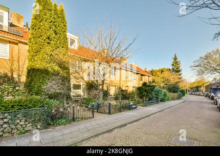 Exterior of modern residential house with brick walls tiled roof and decorative potted plants near entrance against blue sky in town Stock Photo