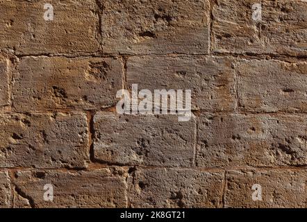 The worn stone wall over time. An old stone wall background. Stock Photo