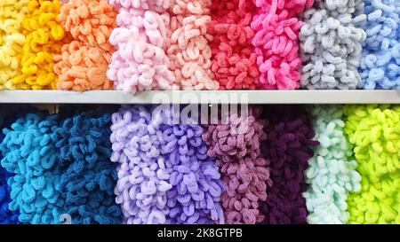 Soft bulk multi-colored yarn on shelf in the store. Stock Photo