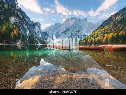 Beautiful wooden boats on Braies lake at sunrise in autumn Stock Photo