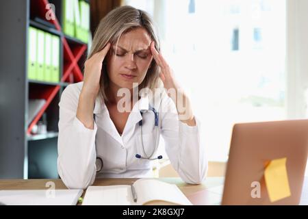 Frustrated doctor touching temples and closed eyes Stock Photo