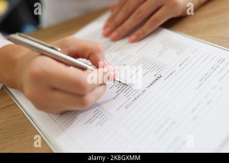 Woman patient filling medical form in clinic Stock Photo