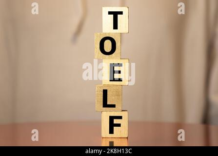 TOEFL - words from wooden blocks with letters, The Test of English as a Foreign Language, TOEFL concept, white background. Stock Photo