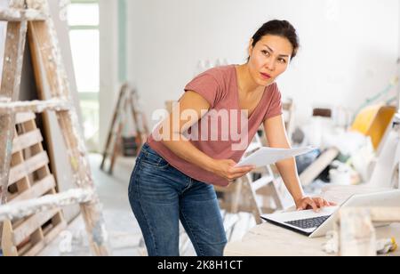 Woman designer using laptop in construction site Stock Photo