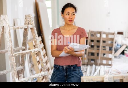 Woman construction manager checking project documentation Stock Photo