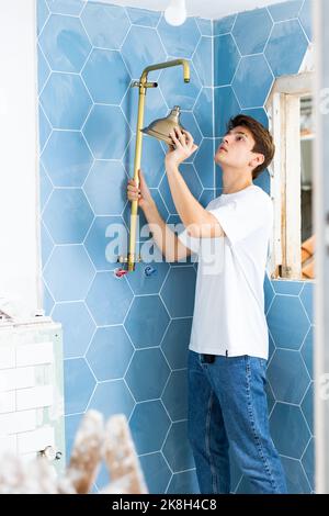 Guy preparing new shower for installation in building under construction Stock Photo