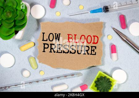 Low Blood Pressure word, medical term word with medical concepts in blackboard and medical equipment background Stock Photo