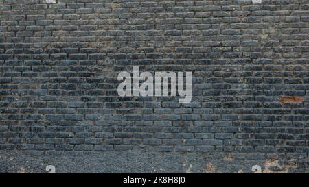Horizontal part of dark brick wall background. Exterior wide old stone bricks texture for pattern. Home or office design backdrop Stock Photo