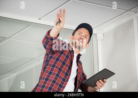 handsome foreman using digital tablet on a ladder Stock Photo