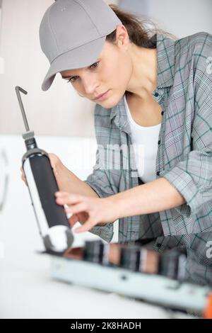 woman installing induction hobs in a kitchen Stock Photo
