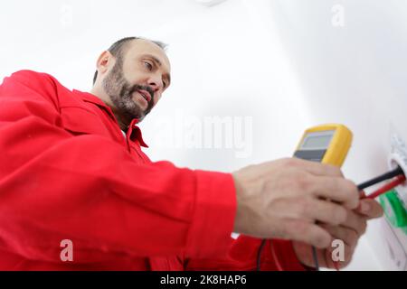 low angle view of electrician testing socket with multimeter Stock Photo