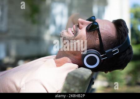 man relaxing outdoors wearing headphones Stock Photo