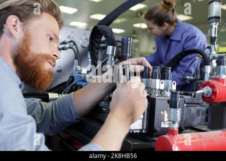 factory engineer operating hydraulic tube bender Stock Photo
