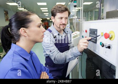 portrait of apprentice working with engineer on cnc machine Stock Photo