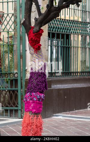 tree trunk dressed with woven fabric of different colors as decoration mexico Stock Photo