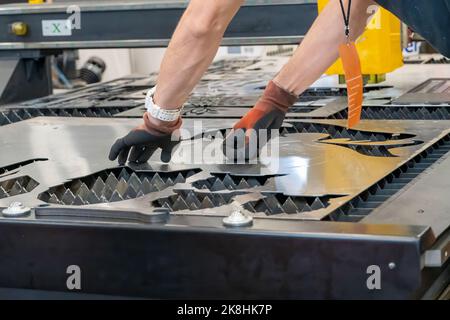 laser cutting machine, cutting wood sheets, while a man takes care of the process, latin america Stock Photo