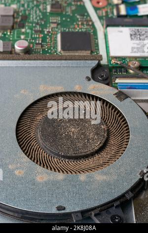 close-up of dusty laptop cooling fan, cleaning dust particles in overheating laptop, fixing, repairing or servicing computer concept, soft-focus Stock Photo